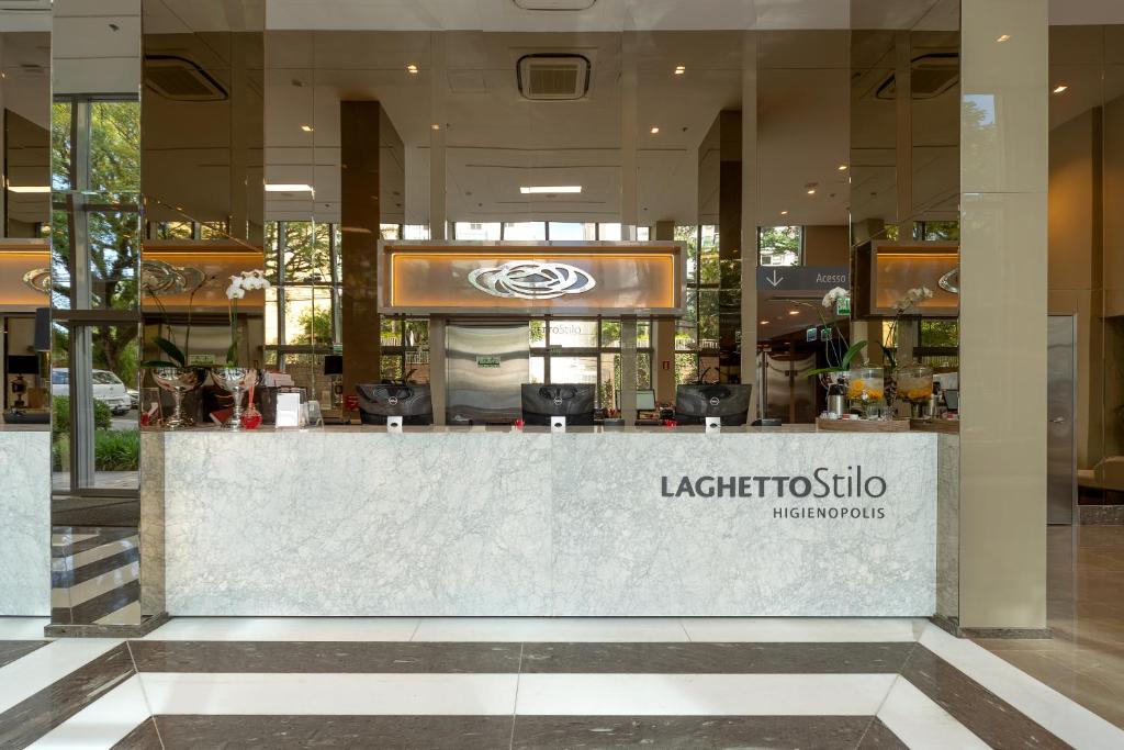 ein Restaurant mit einer Theke in einem Gebäude in der Unterkunft Hotel Laghetto Stilo Higienópolis in Porto Alegre