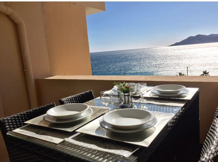 - une table avec des assiettes et des verres et une vue sur l'océan dans l'établissement Appartement 531, à Cannes
