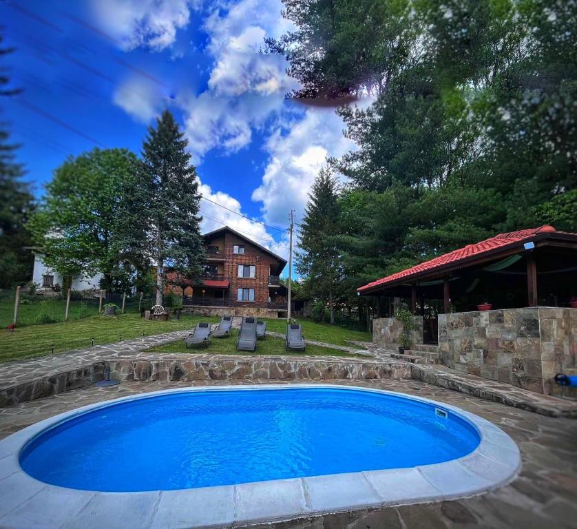 una piscina en un patio con una casa en Къща за гости Милена en Apriltsi