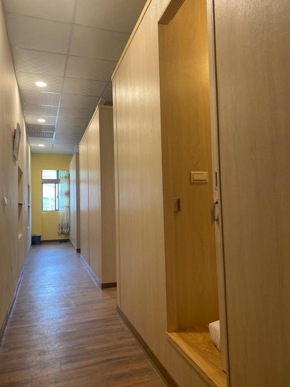 a hallway of an office with wooden floors and a door at Kenting Heng-Chung Art Hostel in Hengchun