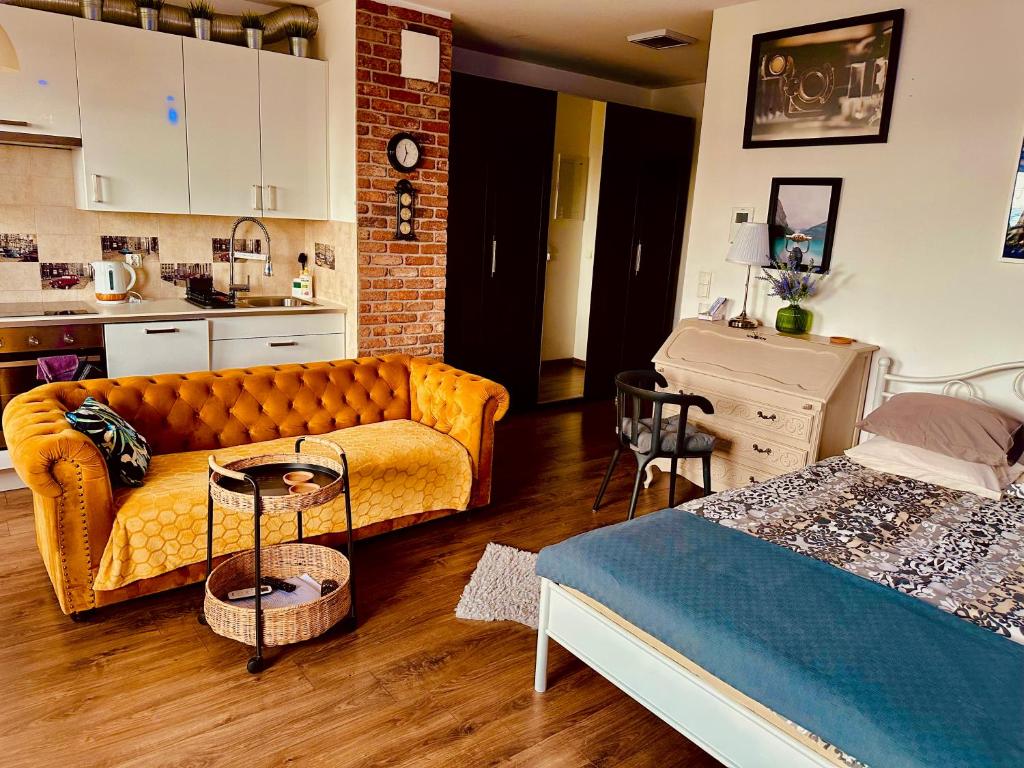 a living room with a couch and a kitchen at Apartament Awiator Gdańsk in Gdańsk