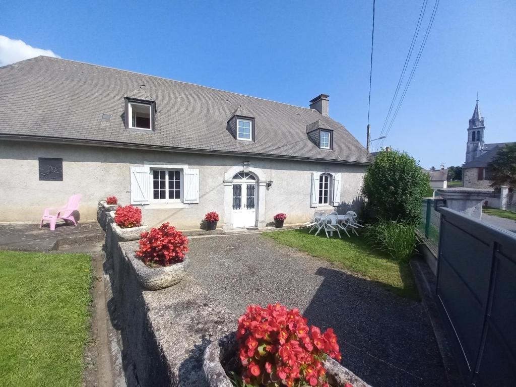 a white house with flowers in front of it at Maison avec jardin in Adé