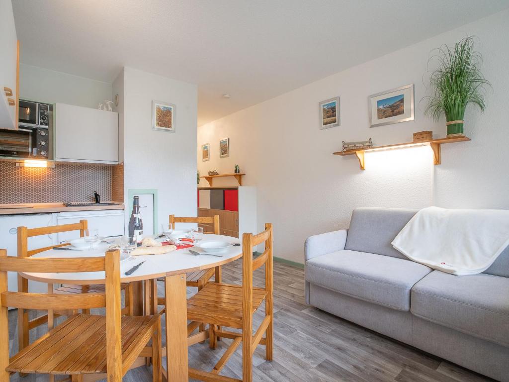 cocina y sala de estar con mesa y sofá. en Apartment Les Asters-26 by Interhome en Les Menuires