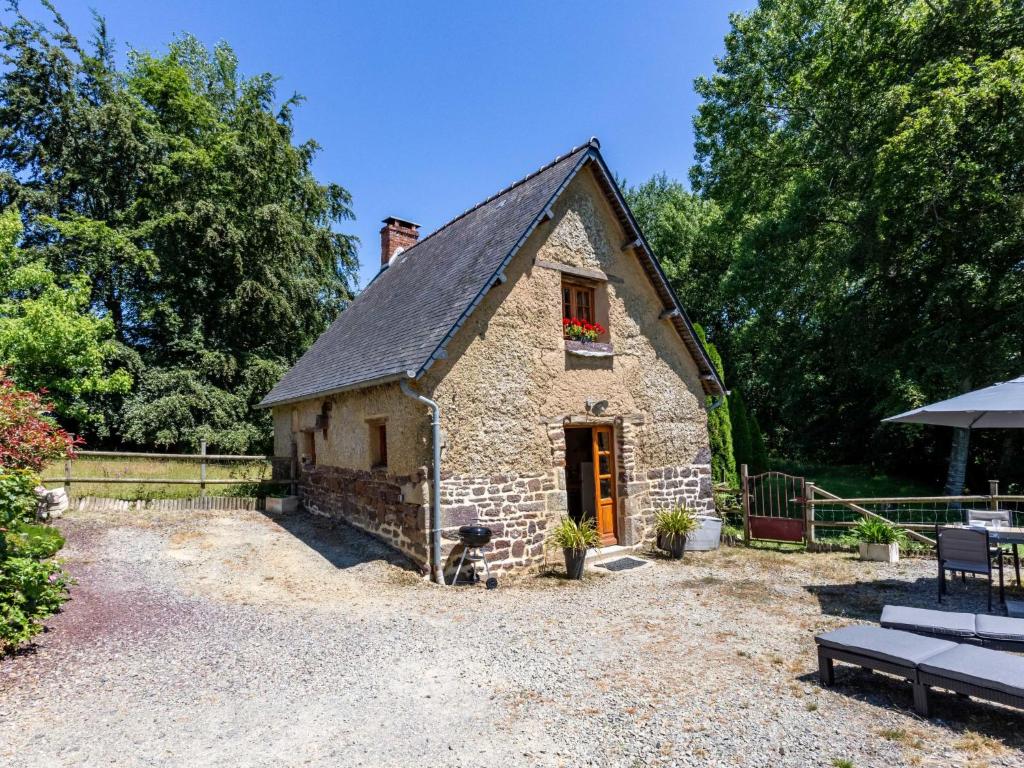 um pequeno edifício de pedra com uma janela e um banco em Holiday Home Au Verger Fleuri - HUD400 by Interhome em Hudimesnil