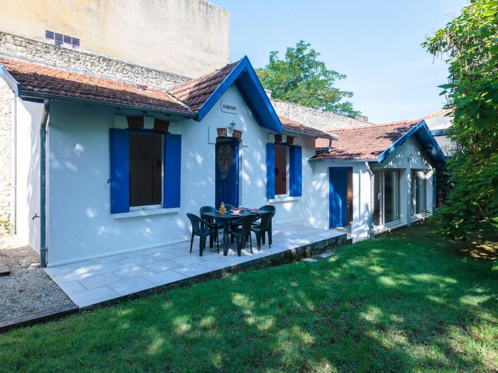 een patio van een huis met een tafel en stoelen bij Holiday Home Domremy by Interhome in Saint-Palais-sur-Mer