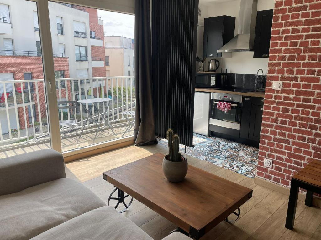 a living room with a couch and a table and a kitchen at Studio Rouen in Rouen