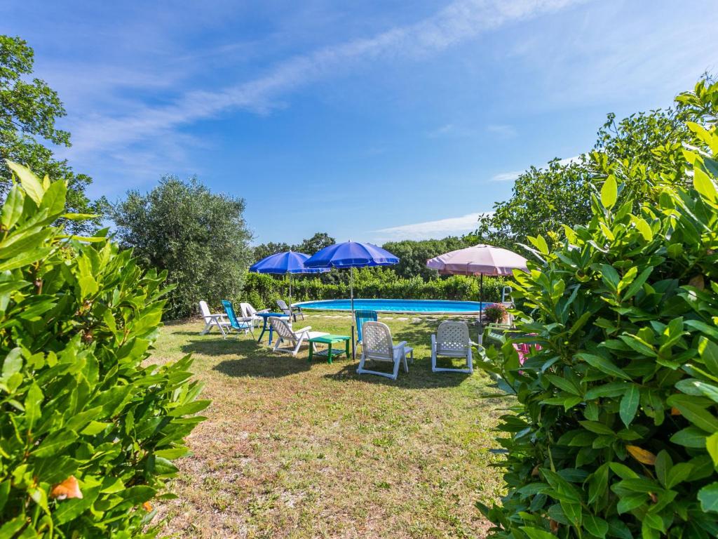 grupa leżaków i parasoli przy basenie w obiekcie Apartment Rosa by Interhome w mieście Casa il Tesorino