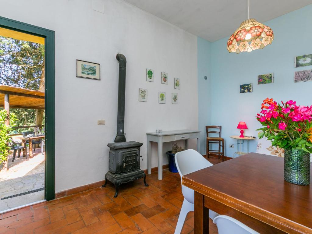 jadalnia z piecem opalanym drewnem i stołem w obiekcie Apartment Rosa by Interhome w mieście Casa il Tesorino