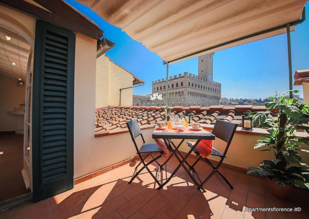 d'une terrasse avec une table et des chaises sur un balcon. dans l'établissement Apartments Florence Piazza Signoria Terrace, à Florence