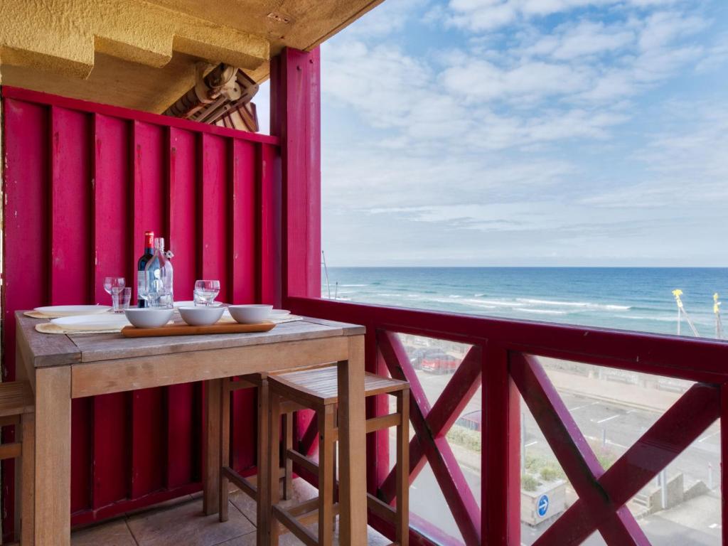 a table on a balcony with a view of the ocean at Apartment Primavéra-8 by Interhome in Lacanau-Océan