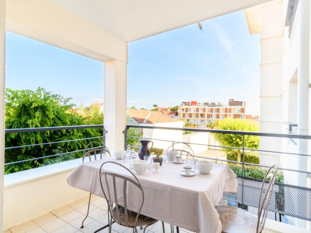 un balcon avec une table et des chaises et une grande fenêtre dans l'établissement Apartment Villa d'Automne by Interhome, à Arcachon