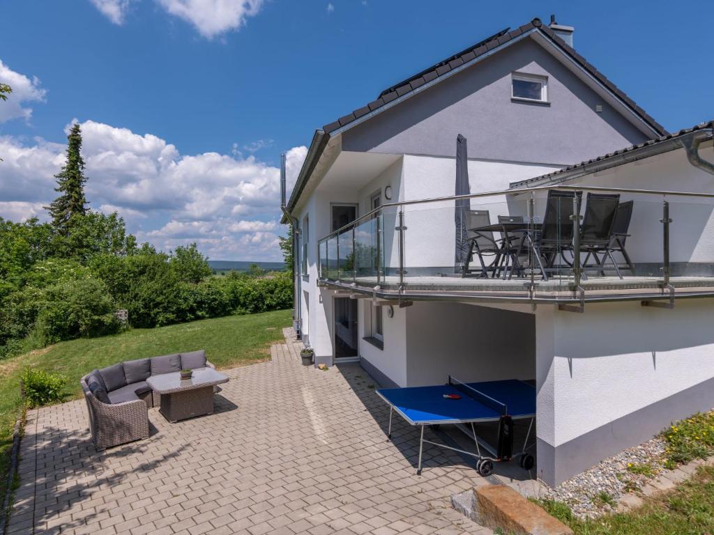 a house with a balcony and a patio at Holiday Home Schwarzwald by Interhome in Dittishausen