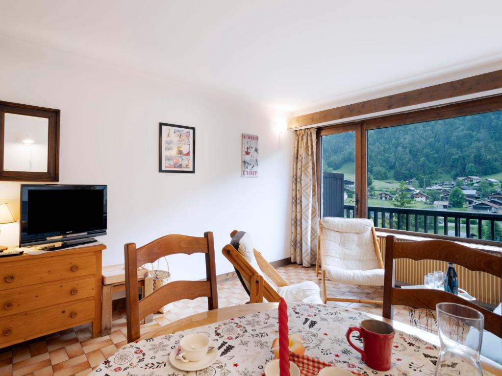 a living room with a television and a table and chairs at Studio Le Bionnassay by Interhome in Les Contamines-Montjoie