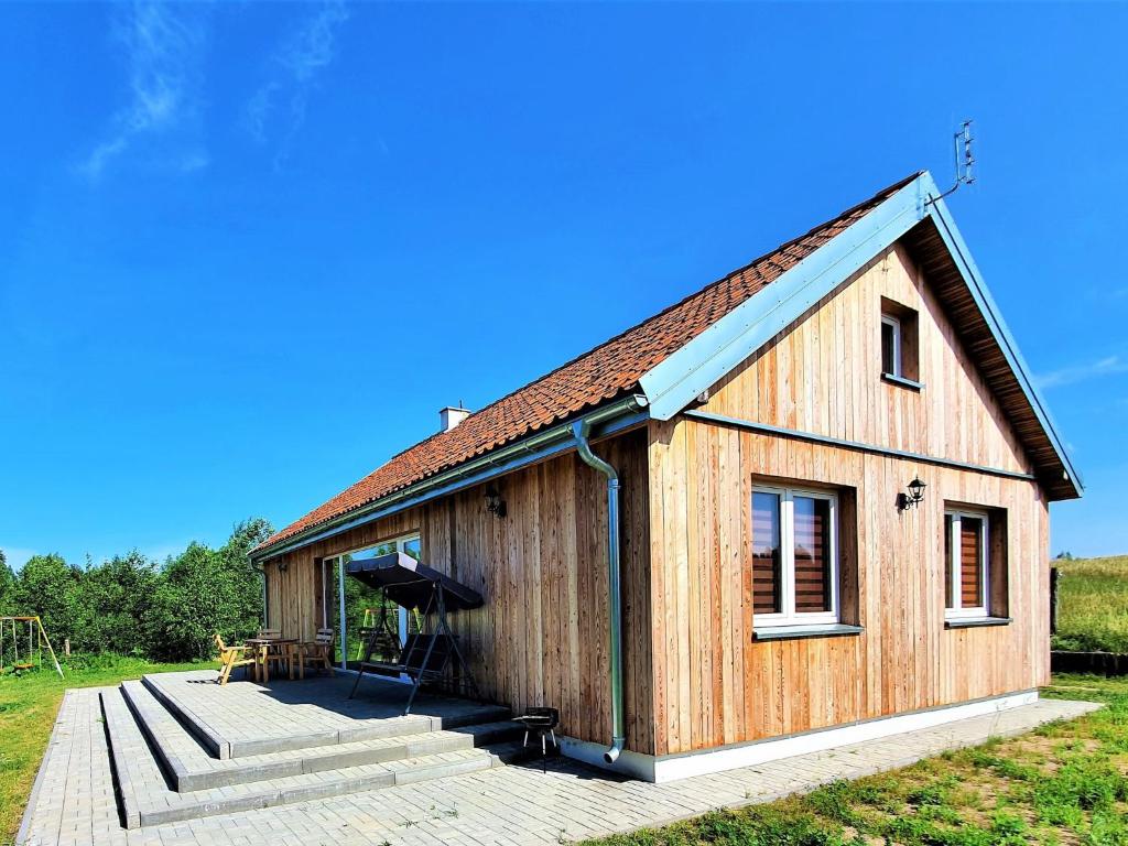 een groot houten gebouw met een veranda en een trap bij Holiday Home Zagroda nad Krutynią by Interhome in Spychowo