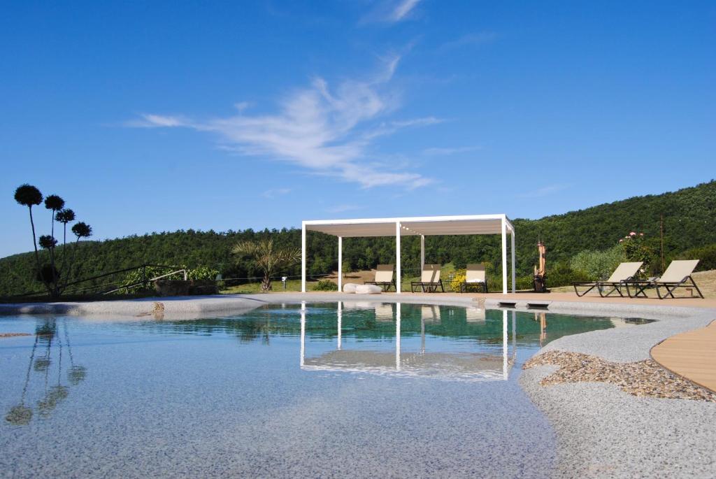 een zwembad met een tuinhuisje in het midden bij VIN Hotel - Wine Resort and Agriturismo Montieri in Montieri