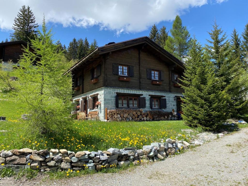 a house on a hill with flowers in front of it at Chalet Chalet Rodas 9 by Interhome in Malmigiuer