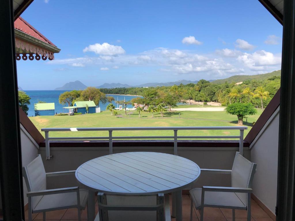 een tafel en stoelen op een balkon met uitzicht op de oceaan bij 2 Pièces Premium avec terrasse vue mer Résidence Pierre et Vacances in Sainte-Luce