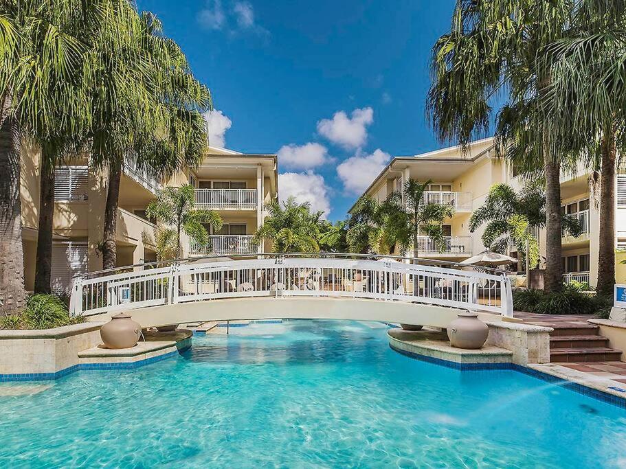 un pont sur une piscine en face d'un bâtiment dans l'établissement Noosa Beachside Apartment, à Noosa Heads