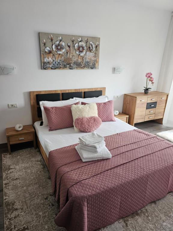 a bedroom with a large bed with pink and white pillows at Apartament Cristal in Arad