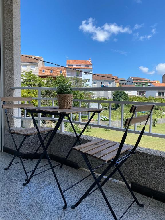 a table and a chair sitting on a balcony at A Xaneiriña in Camariñas