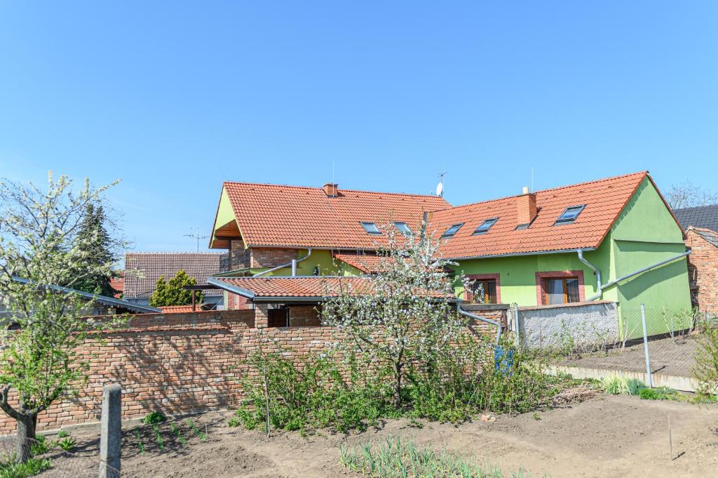una casa verde con techos rojos y una pared de ladrillo en Ubytování na výminku, en Mikulčice