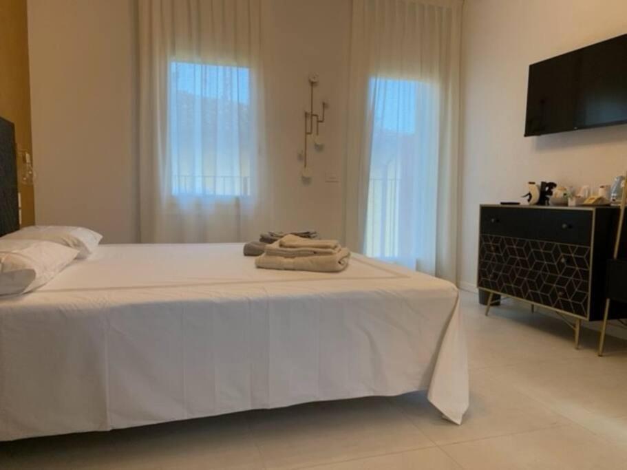 a bedroom with a white bed with towels on it at Locanda Carolina Mastino Scala in Sirmione