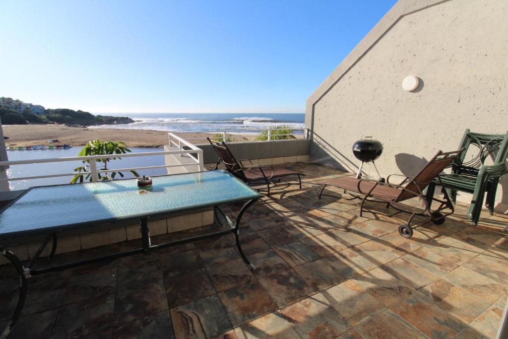 a patio with chairs and a table and the beach at Inn On The Sea 8 in Margate