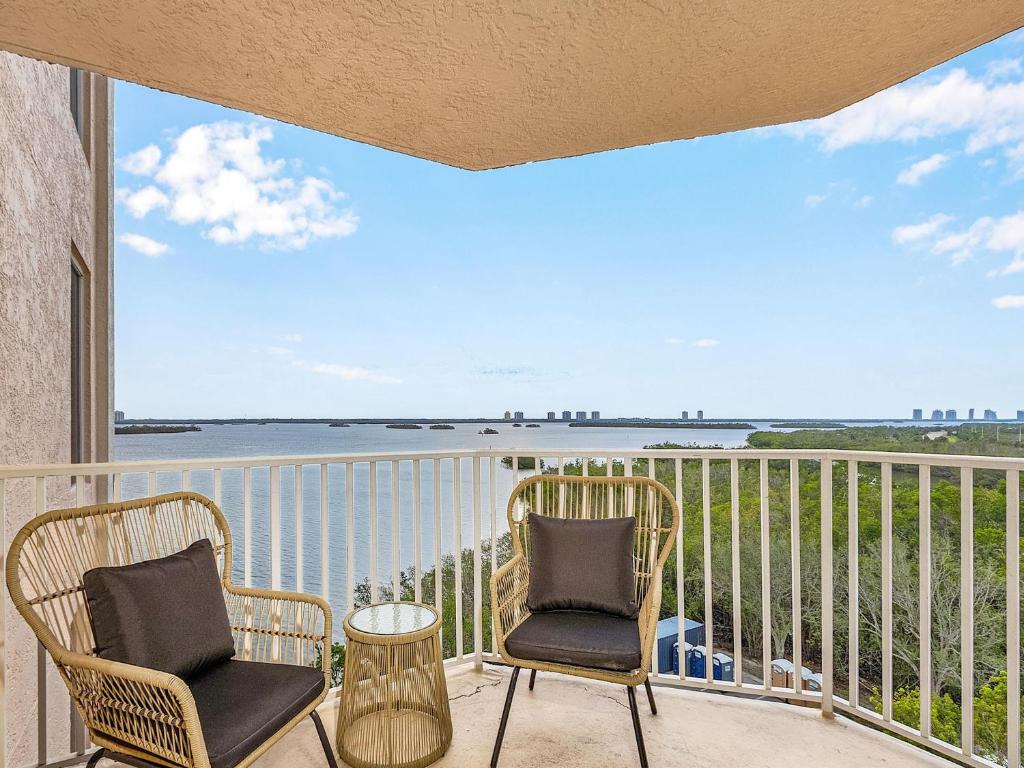 a balcony with two chairs and a view of the water at Lovers Key Resort 601 in Fort Myers Beach
