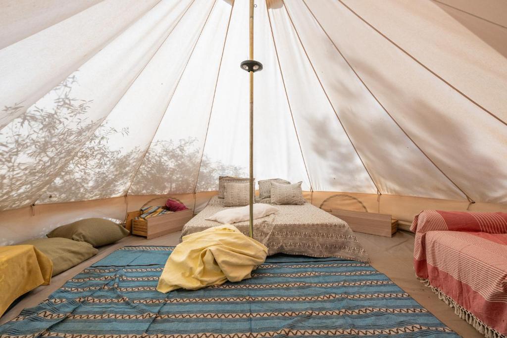 a room with a tent with two beds and a rug at Romance Tent In The Eucaliptus in Capitana