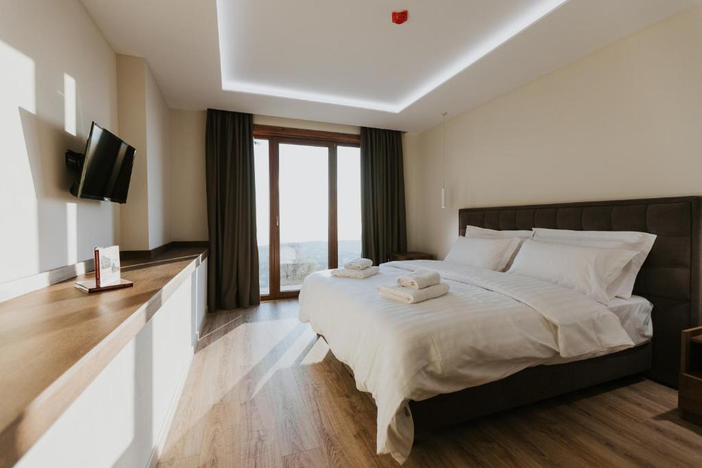 a bedroom with a large bed with a flat screen tv at Hotel Kroi near castle entrance castle and town view in Krujë