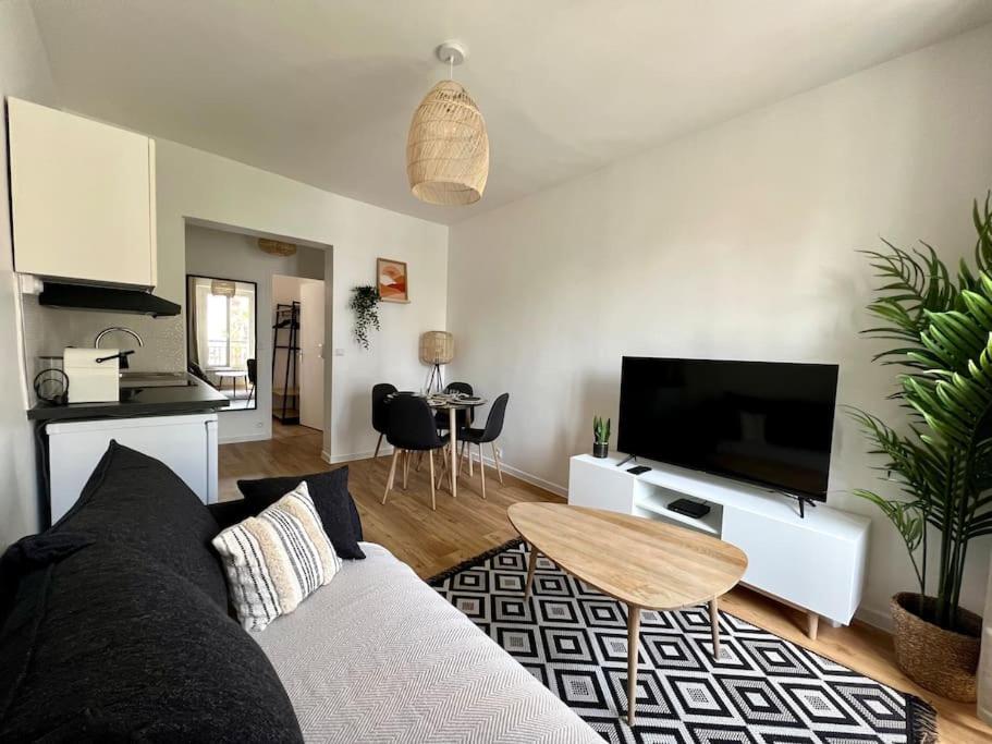 un salon avec un canapé et une télévision à écran plat dans l'établissement La Maison Cosy Paris Centre - Métro - Wifi, au Kremlin-Bicêtre