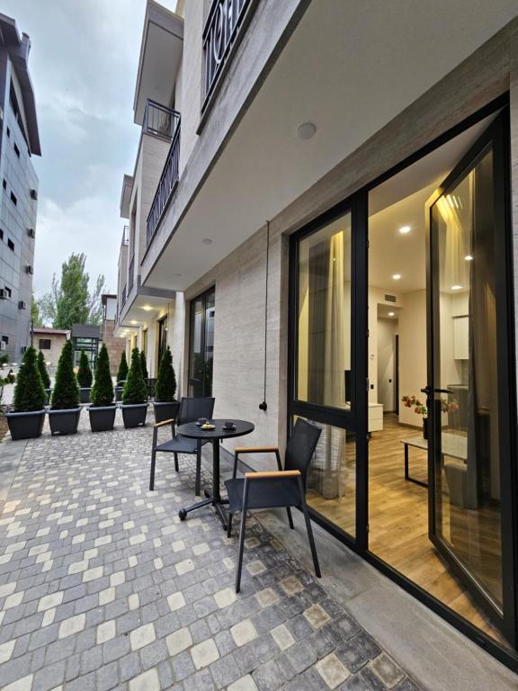 a patio with chairs and a table in front of a building at Orion ApartHotel in Yerevan