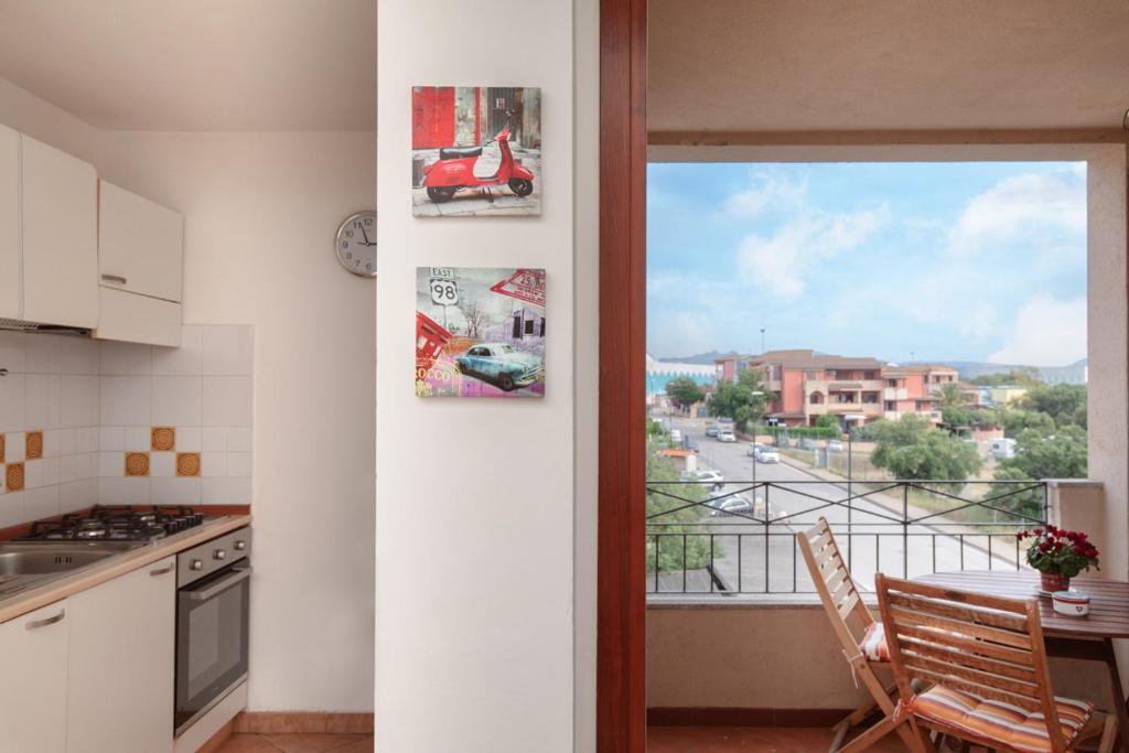 een keuken met een balkon met uitzicht op een straat bij Casa Olbiamare by Wonderful Italy in Olbia