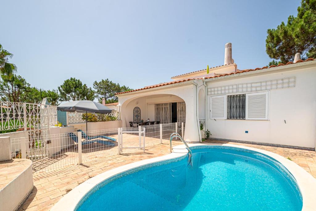 a swimming pool in front of a house at BeGuest Vale de Lobo 932 Villa in Almancil