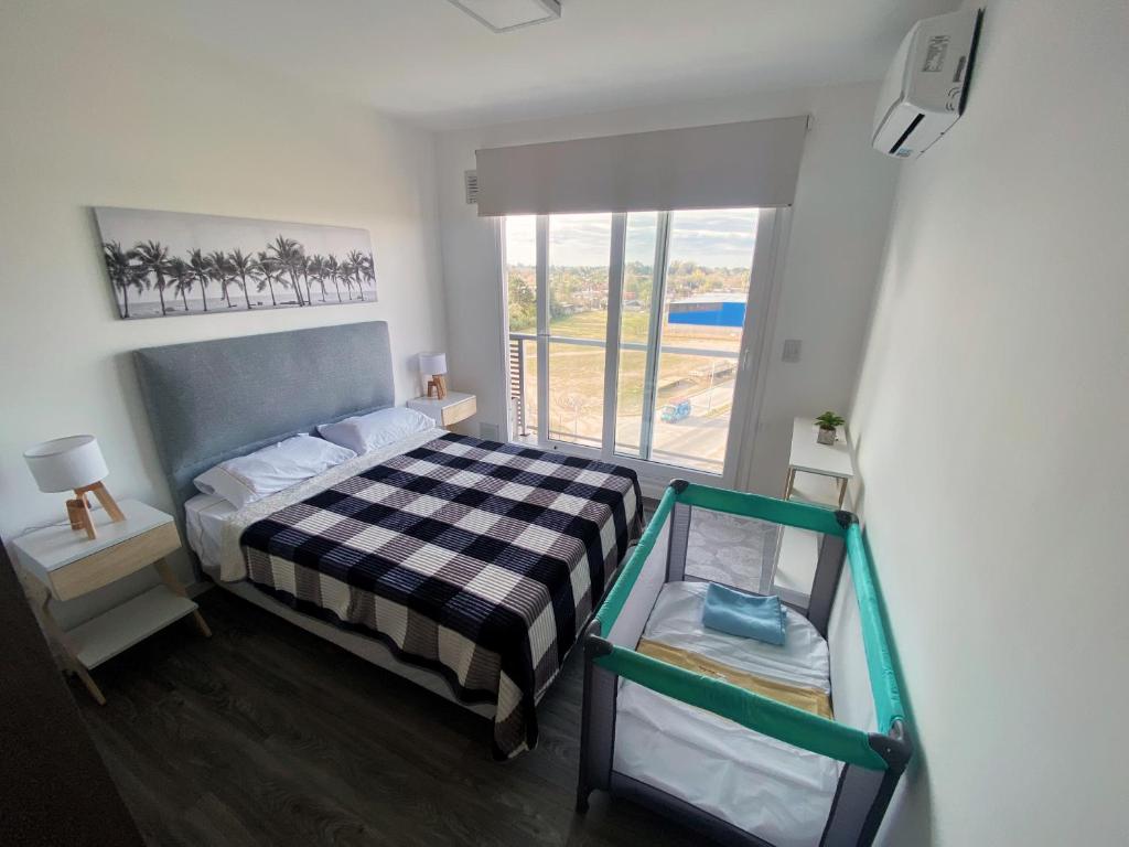 a small bedroom with a bed and a window at Departamentos Premium - Boero Rentals in Belén de Escobar