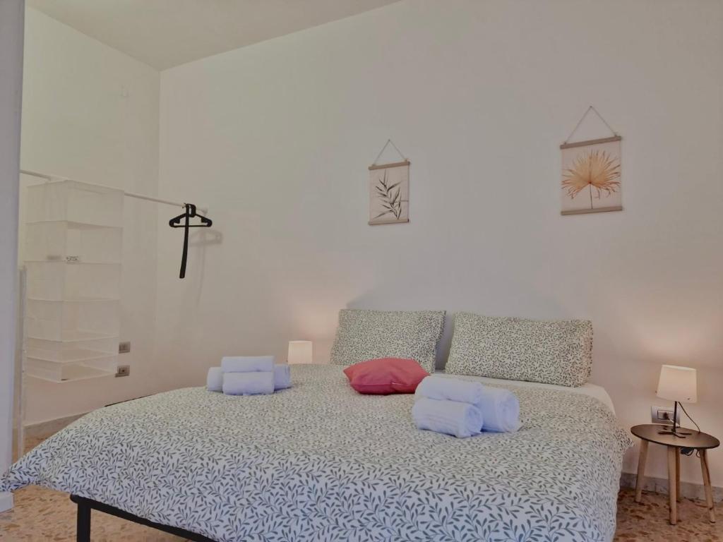 una camera da letto con un letto con cuscini blu e rosa di Guest House Service Modugno - ZONA INDUSTRIALE a Modugno