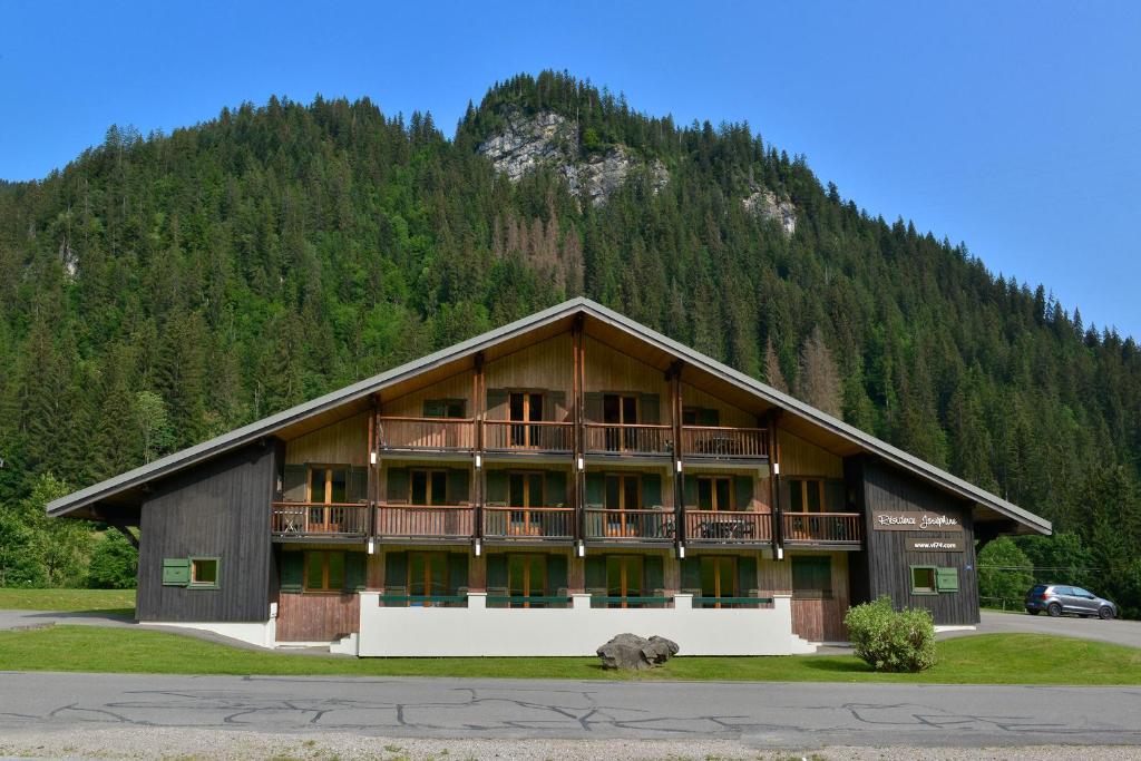 a large building with a mountain in the background at Résidence Joséphine in Châtel