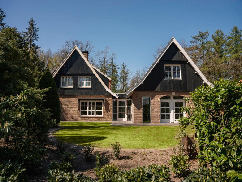 una casa con un césped verde delante de ella en Holiday Home Het Landhuis by Interhome, en Losser