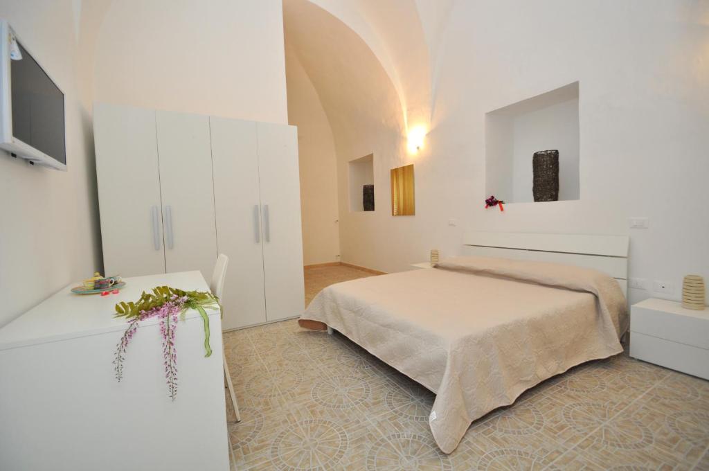 a bedroom with a bed in a white room at Palazzo Vaglio in Alliste