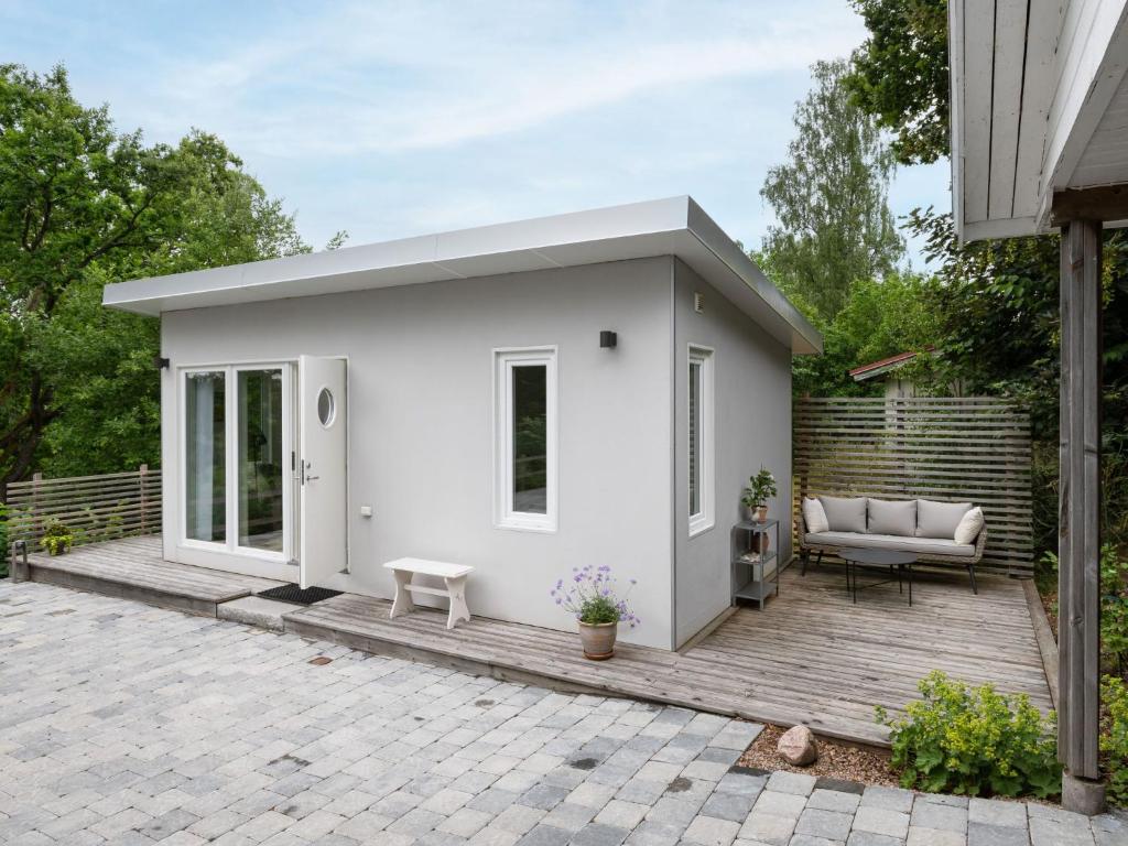 uma pequena casa branca num deque de madeira em Holiday Home Solbacken by Interhome em Alingsås