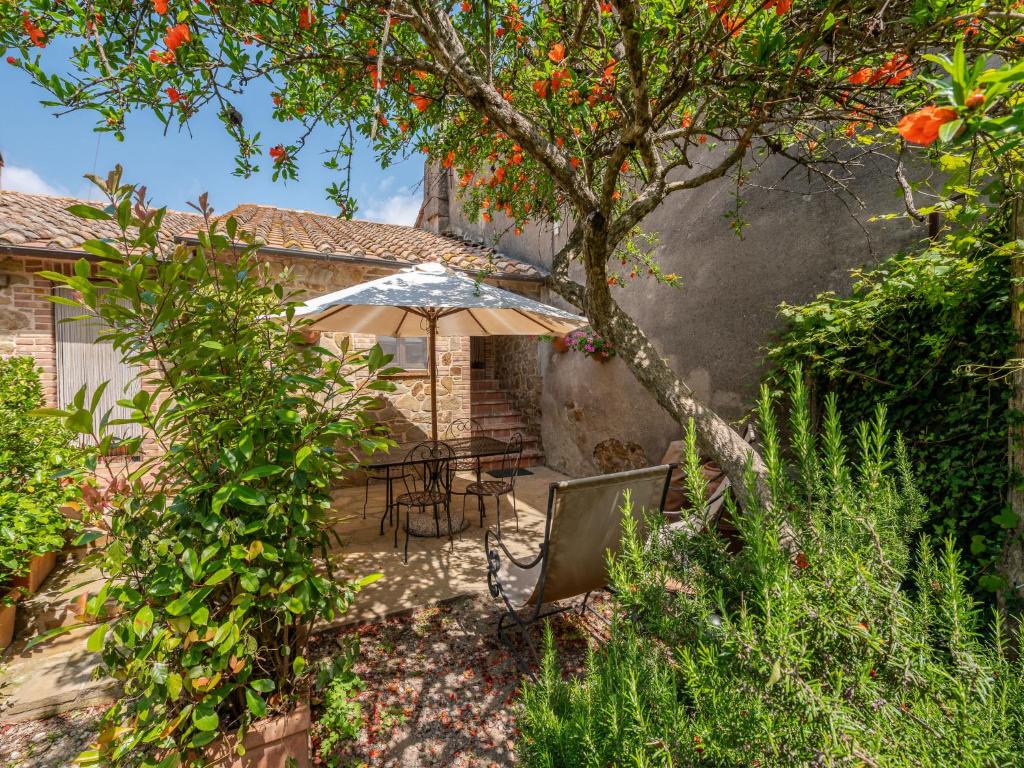 a patio with a table and an umbrella at Holiday Home Carola by Interhome in Cinigiano