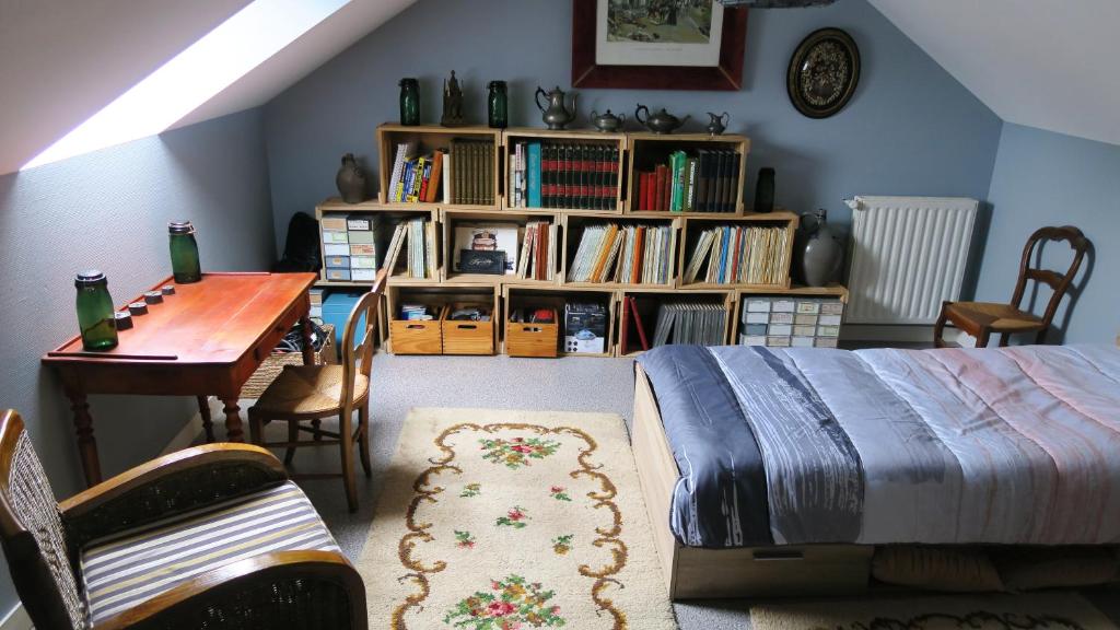 a bedroom with a bed and a table and a desk at Chez Hervé in Saint-Mars-sur-Colmont