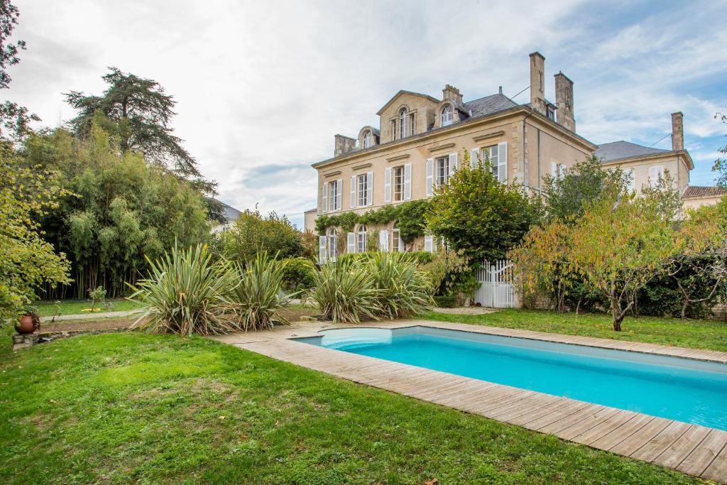 una finca con piscina frente a una casa en La Maison de maître, en Fontenay-le-Comte