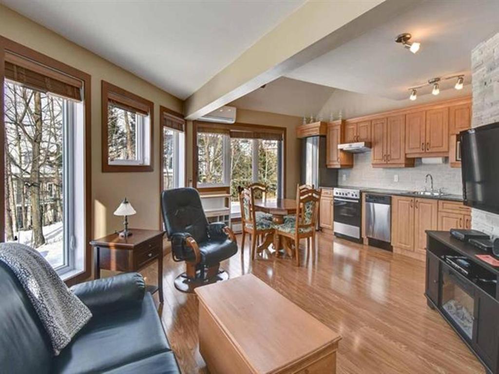 a kitchen and living room with a couch and a table at Bright Condo near the Lake by GLOBALSTAY in Mont-Tremblant