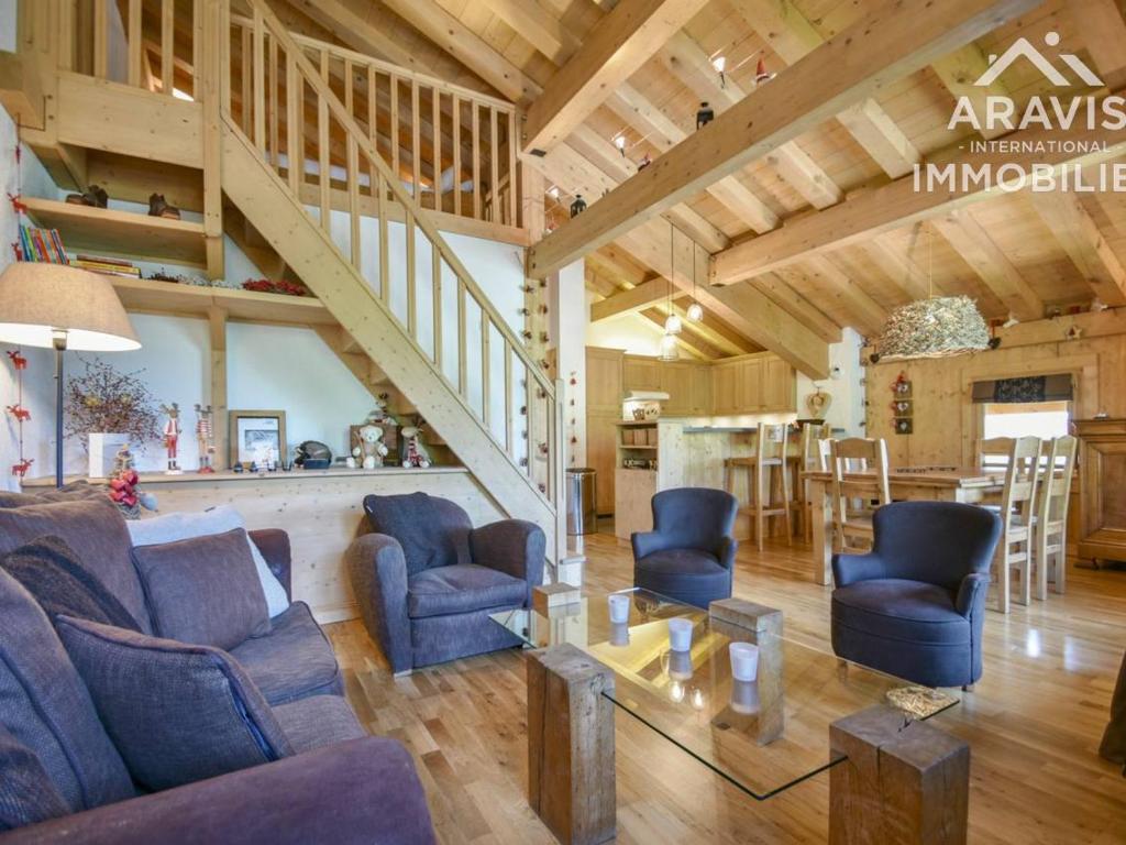 uma grande sala de estar com cadeiras azuis e uma mesa em Appartement Le Grand-Bornand, 3 pièces, 7 personnes - FR-1-391-97 em Le Grand-Bornand