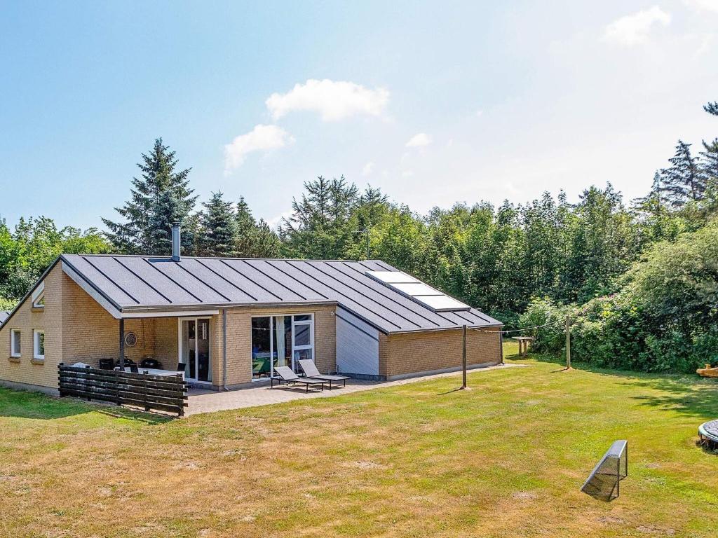 une maison avec un toit solaire sur une cour dans l'établissement 12 person holiday home in Sp ttrup, à Ålbæk