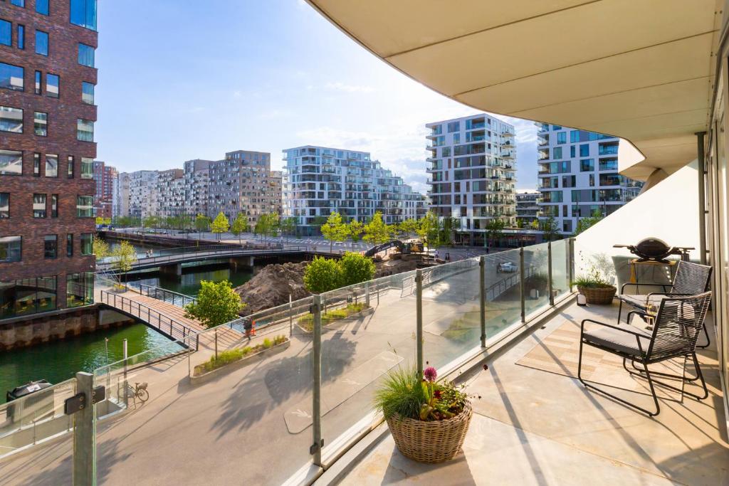 a balcony with a view of a river and buildings at Lys 3 værelses lejlighed med 26 m2 sydvendt altan in Aarhus
