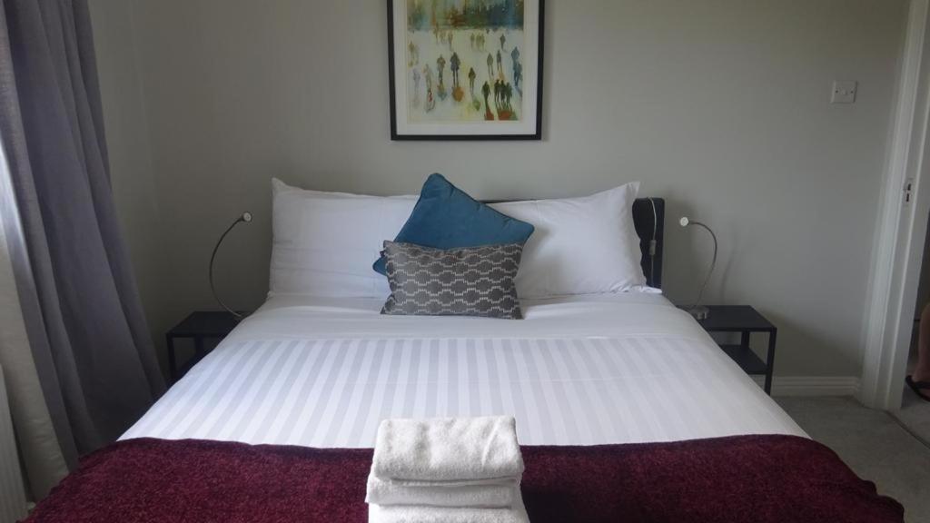 a large white bed with pillows on top of it at Ger's Lodging in Galway