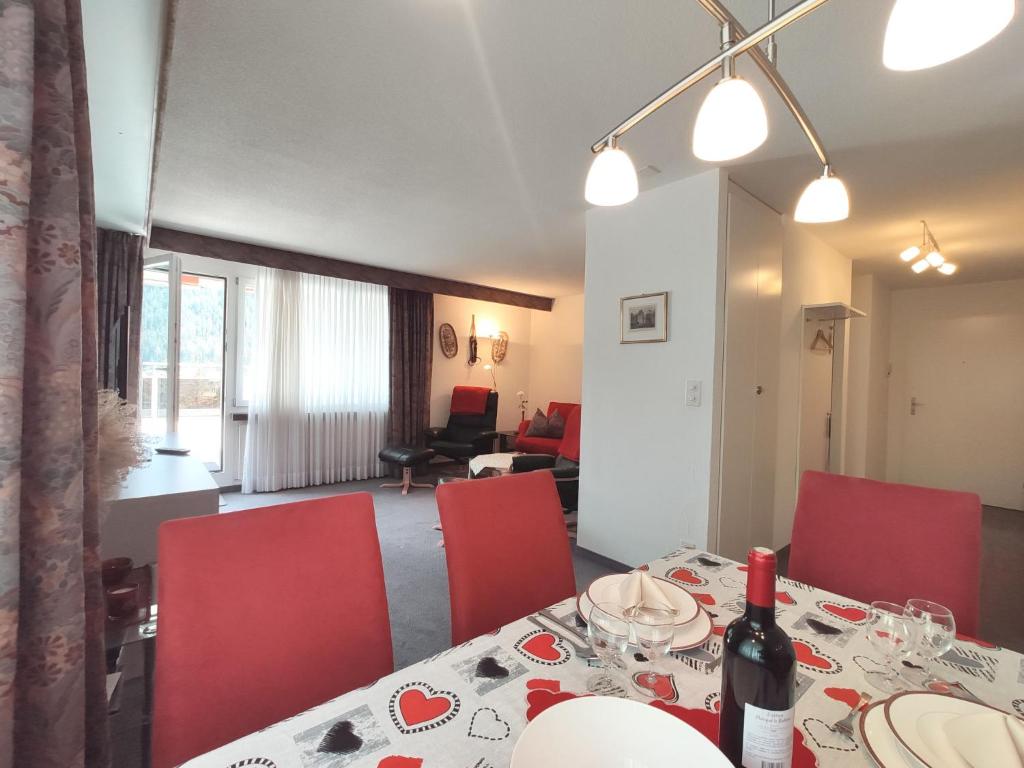a dining room with a table and red chairs at Apartment Allod-Park-32 by Interhome in Davos