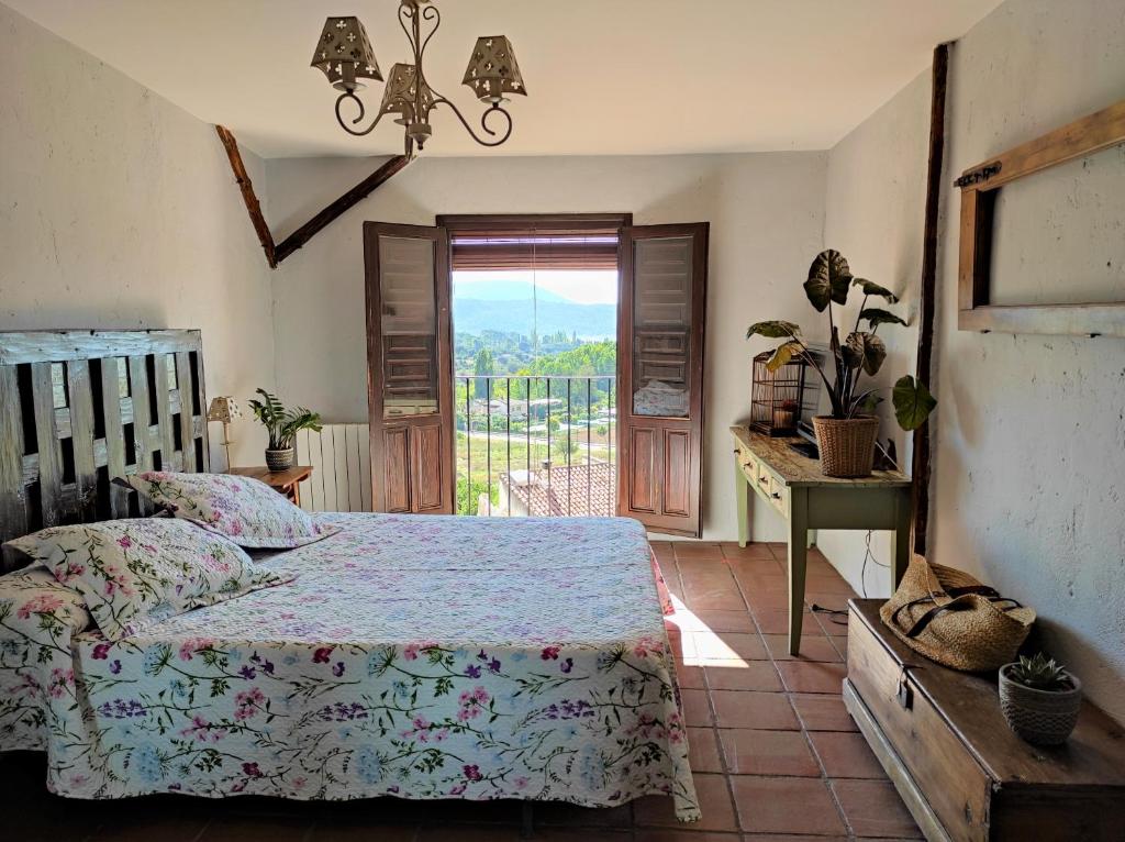 a bedroom with a bed and a window and a table at Casa Rural El Botánico in Durón